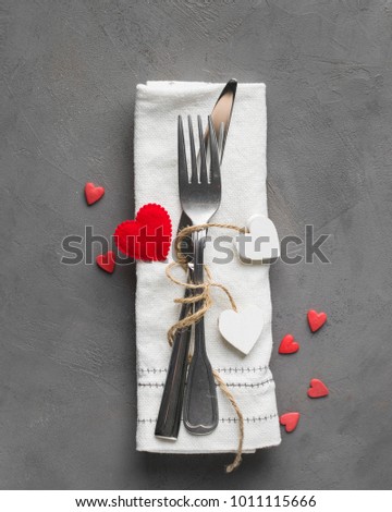 Valentines day meal background with white wood vintage and red candy hearts, fork, knife and napkin. Romantic holiday table setting. Beautiful background with blank. Restaurant concept. Flat lay