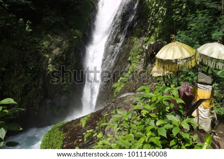 Traditional Balinese umbrellas near a waterfall