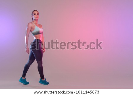 sports girl posing on a dark background. Place for text