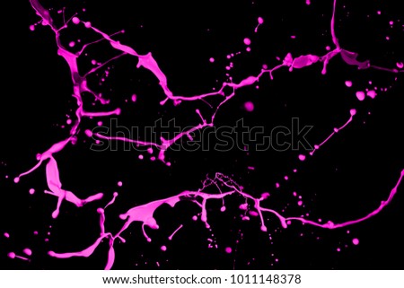 Pink paint splash isolated on black background.