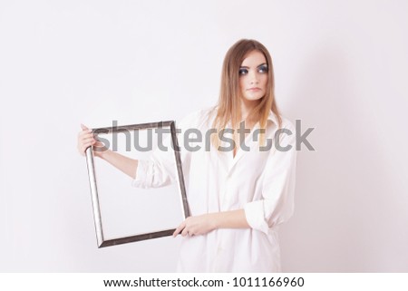 Sad beautiful girl holding a frame in his hands