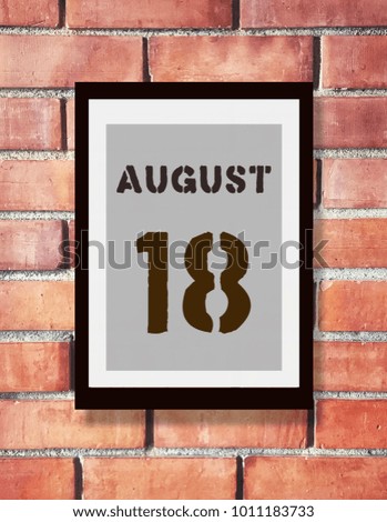 August 18th. 18 August calendar on the wood photo frame with brown brick background. Summer day