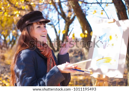 Young woman having fun laughing near easel