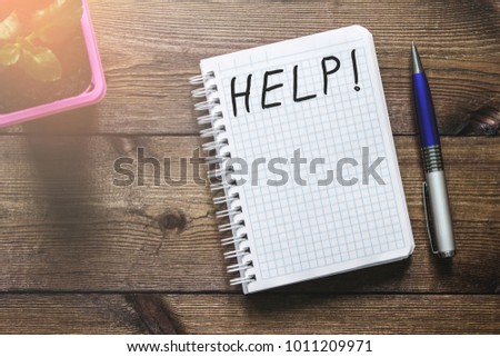 Help text on  Notepad, flower and pen on table