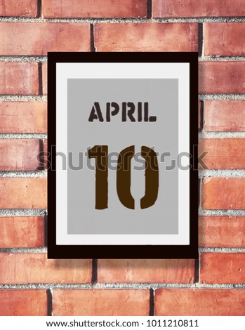 April 10th. 10 April calendar on the wood photo frame with brown brick background. Spring day