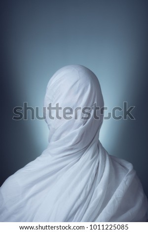 Upper body of a person wrapped in sheets  Royalty-Free Stock Photo #1011225085