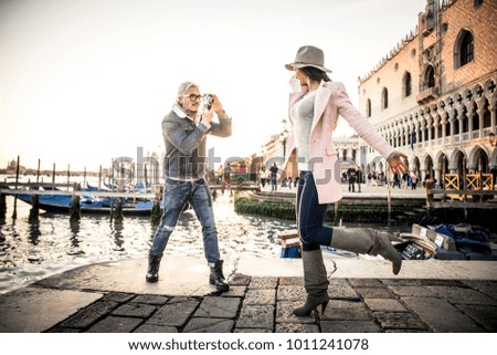 Beautiful couple in Venice, Italy - Lovers taking pictures with a vintage styled camera and having fun in Saint Mark Square, Venice