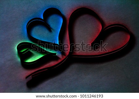 Valentine's day abstract background with cut paper colorful hearts on dark background.