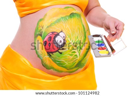 pregnant woman with a picture on her stomach, holding a palette of colors in hand. close-up. isolated in a white  background. without a face