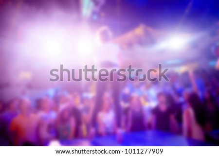 Blurred for background night club. Artist performs songs and club show from stage during concert at nightclub. Artist on club stage during night party.