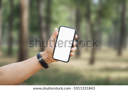 Man holding smart phone with blurred background. For Graphic display montage.