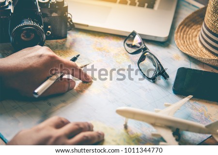 Travelers are planning a trip by searching the route on the map and searching for information on the internet. Royalty-Free Stock Photo #1011344770