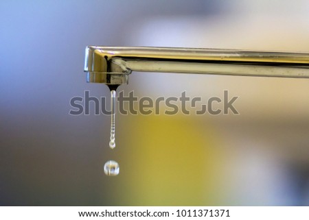 Close-up of faucet with turned drop water in modern bathroom. Horizontal crop with shallow depth of field