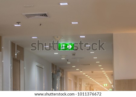 green emergency exit sign in hospital showing the way to escape
