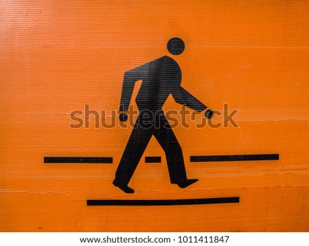 The orange-black pedestrian symbol