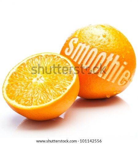 Fresh oranges with one halved to show the juicy pulp and the other whole with the word Smoothie cut out of the rind in an orange smoothie concept