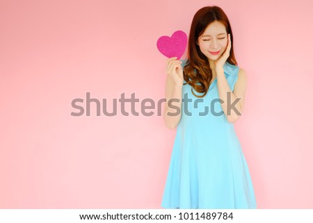 Portrait beautiful asian woman on pink background, happy valentine day in love concept, model holding red heart sign in hand Royalty-Free Stock Photo #1011489784
