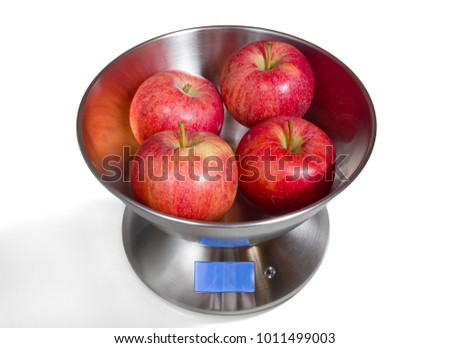 Modern electronic metal kitchen weighing scales with red apples