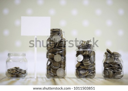 Accumulated coins stacked in glass jars on the floor
