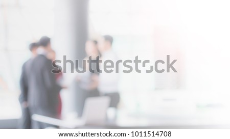 Blurred office interior space with businessman and businesswoman meeting background with copy space.