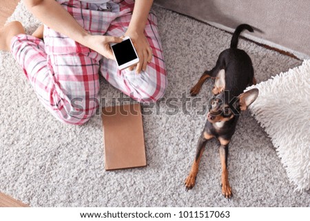 Woman with cute toy terrier indoors