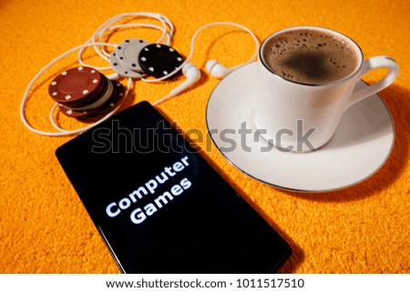 Computer game concept poker chips. In the picture there is a smartphone and headphones as a symbol playing to online game.