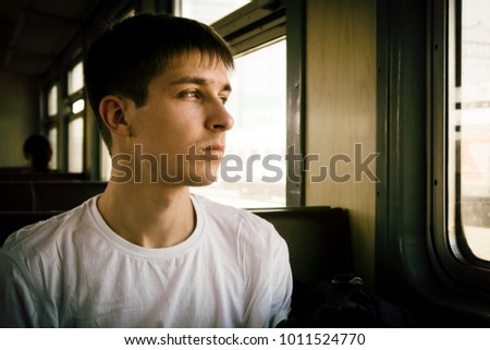 Toned Photo of Pensive Young Man sit in the Train