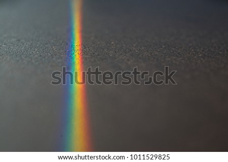 Close up macro photo of so beautiful rainbow glare spectrum lighting specular reflection on the floor. Sun ray shining through window glass that work as prism and reflex colorful spectrum on floor.