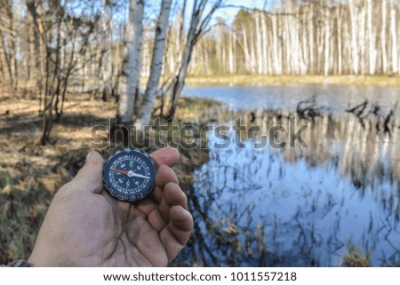 Compass in hand. Orientation on a walk with a navigation device.