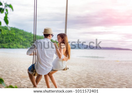 couple lover enjoy honeymoon and long vacation on the sea beach, siiting on the swing together relax and confortable, valentine occasion Royalty-Free Stock Photo #1011572401