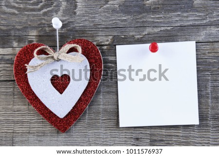 Designer heart and photo paper hanging on wooden background