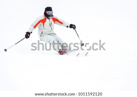 Alpine skier skiing downhill over white snow background