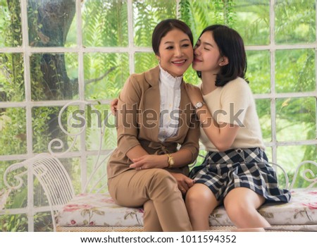 Teen daughter hugging mother and kiss her Mather Mather Day concept