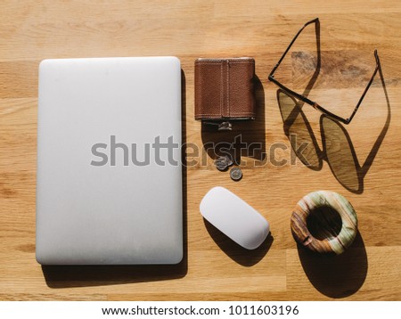 Men's Accessories on the light-brown table. Silver computer with