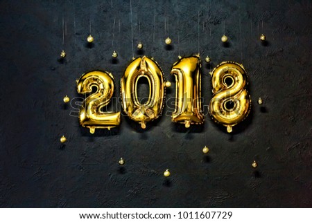 2018. Inflatable Gold Numbers on the Background of the Black Stone Wall New Year
