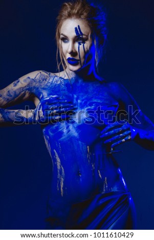 beautiful girl, blue matter poses half dark, blue paint flows through the body, photo studio studio, paint on a bare body