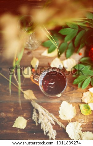 Top view of Cup of hot tea and lemon and Peanut cookies, autumn leaves on wooden table background. Copy space