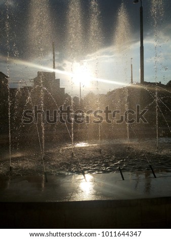 Water fountain in front of the sun