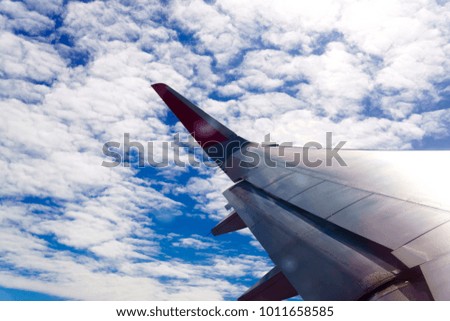 The wings of the plane float above the clouds and the sky is bea
