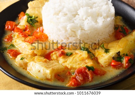Pescado encocado or fish with coconut sauce is an Ecuadorian coastal dish close-up on a plate on a table. Horizontal

