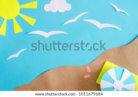 Summer background with sailboat sailing in the sea, gulls, clouds, beach umbrella and mat. Paper cut.