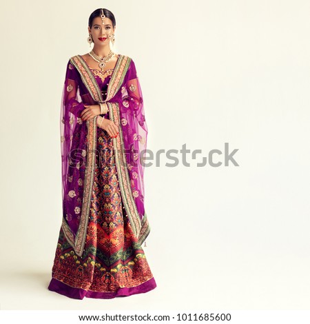 Portrait of beautiful indian girl. Young hindu woman model with kundan jewelry set. Traditional India costume lehenga choli or sari Royalty-Free Stock Photo #1011685600