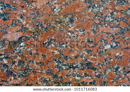 Red grey granite background and wallpaper. Blotches of red granite in a gray mass of natural stone.