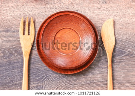 Empty wooden plate and bamboo tableware on the table top view. Background with cutlery.