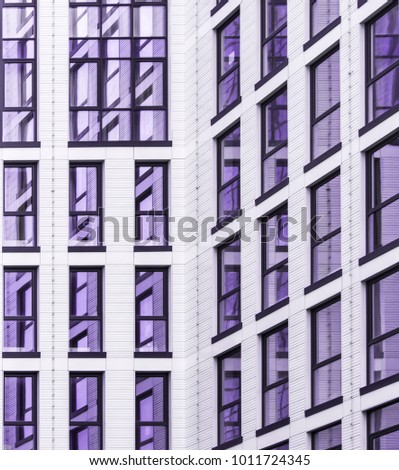details of the facade of a modern skyscraper made of glass and steel closeup. geometry in colors of the year 2018, ultra violet.