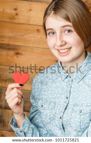 child holds a heart in her hands, a girl with a red heart in her hands, a mother's day, orphans