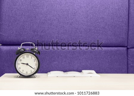 alarm clock next to sockets and switches in colors of the year 2018, ultra violet.