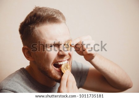 Bitcoin. Man bites a gold coin with his teeth Royalty-Free Stock Photo #1011735181
