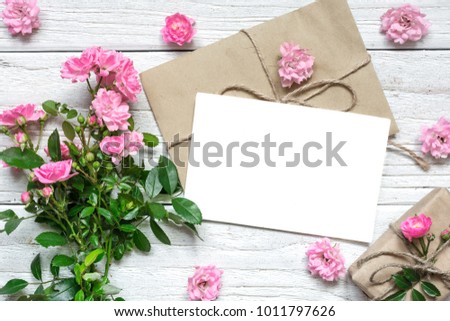 pink rose flowers bouquet with blank greeting card and gift box. holiday background. wedding invitation. top view. flat lay