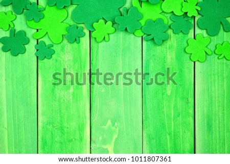 St Patricks Day top border of shamrocks over a green wood background